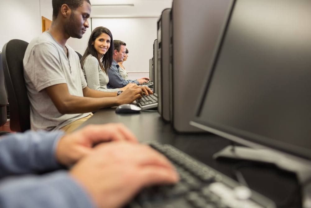 Woman looking up from computer class in college